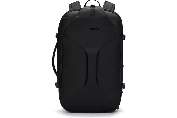 hard-shell carry-on open on a hotel bed, packed