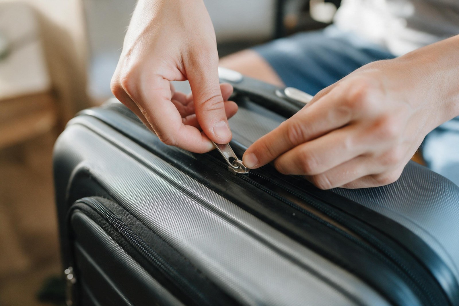 hands testing a zipper slider on a used carry-on, full extension