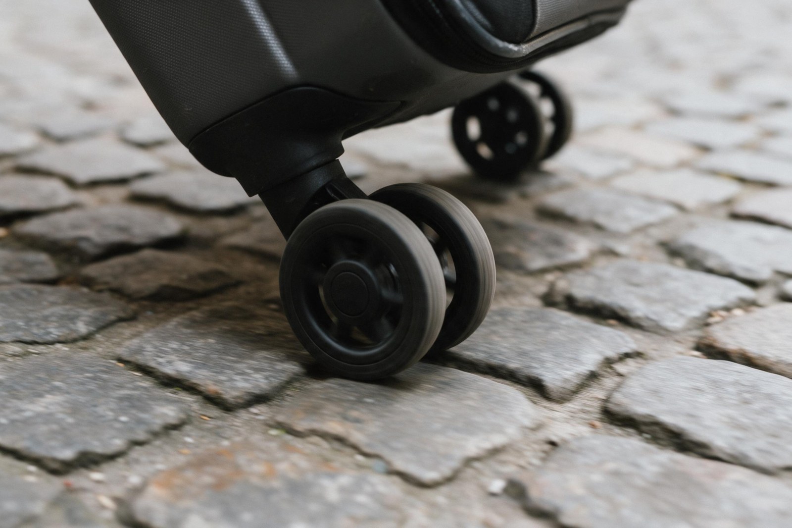 rolling suitcase wheels on cobblestone street