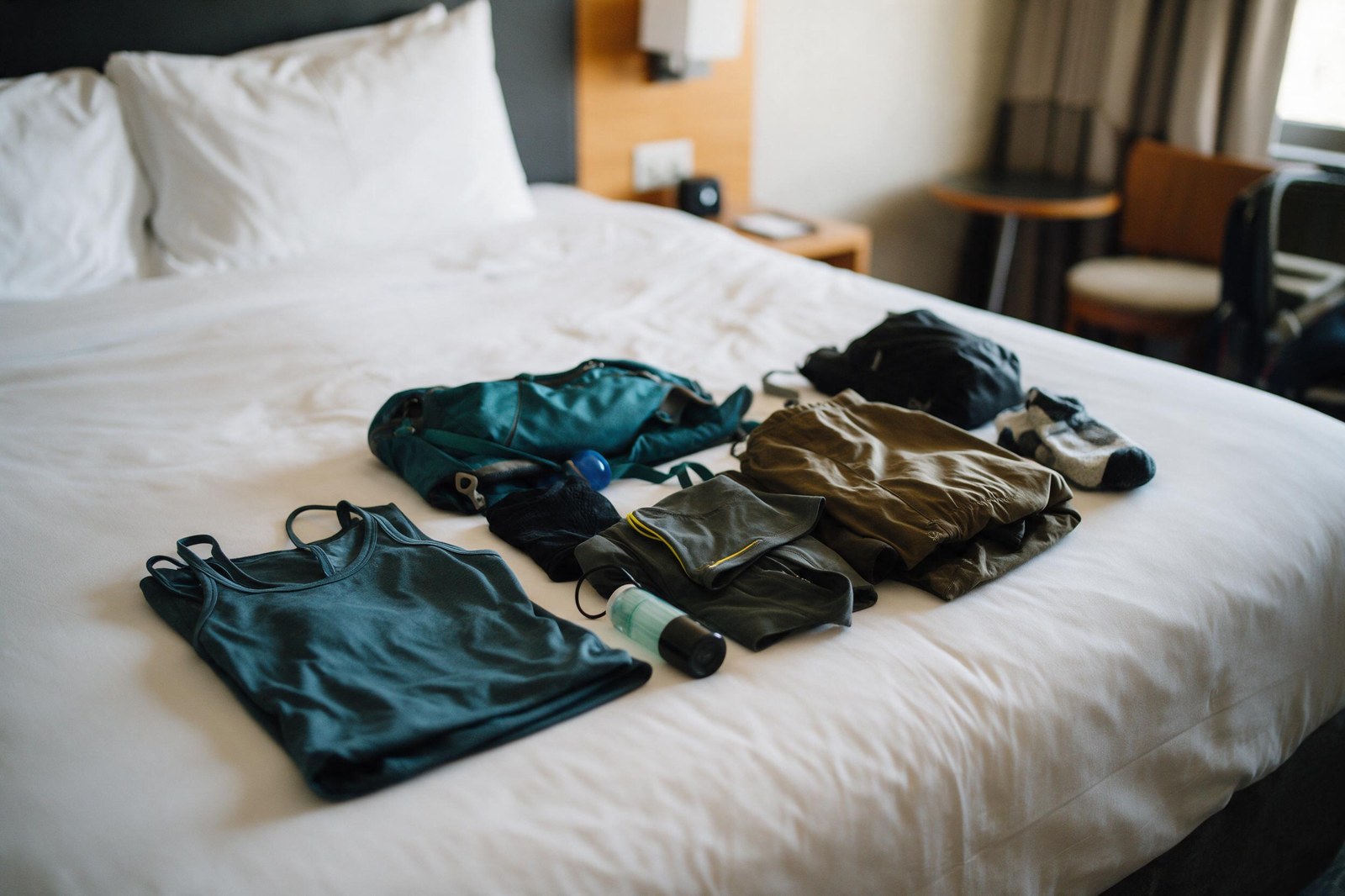 base layer and midlayer set laid out on a hotel bed