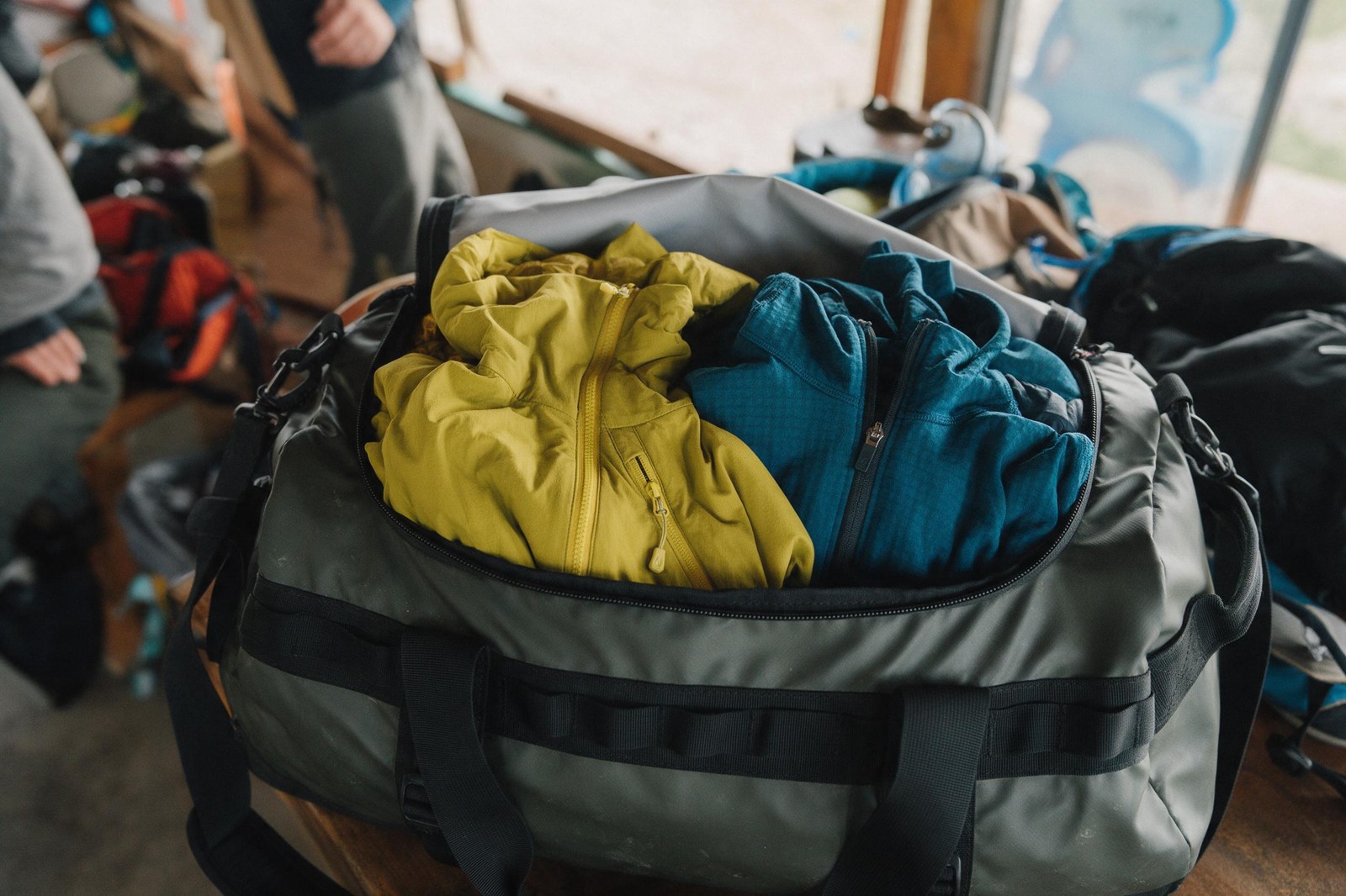 shell jacket and midlayer combo packed into a duffel