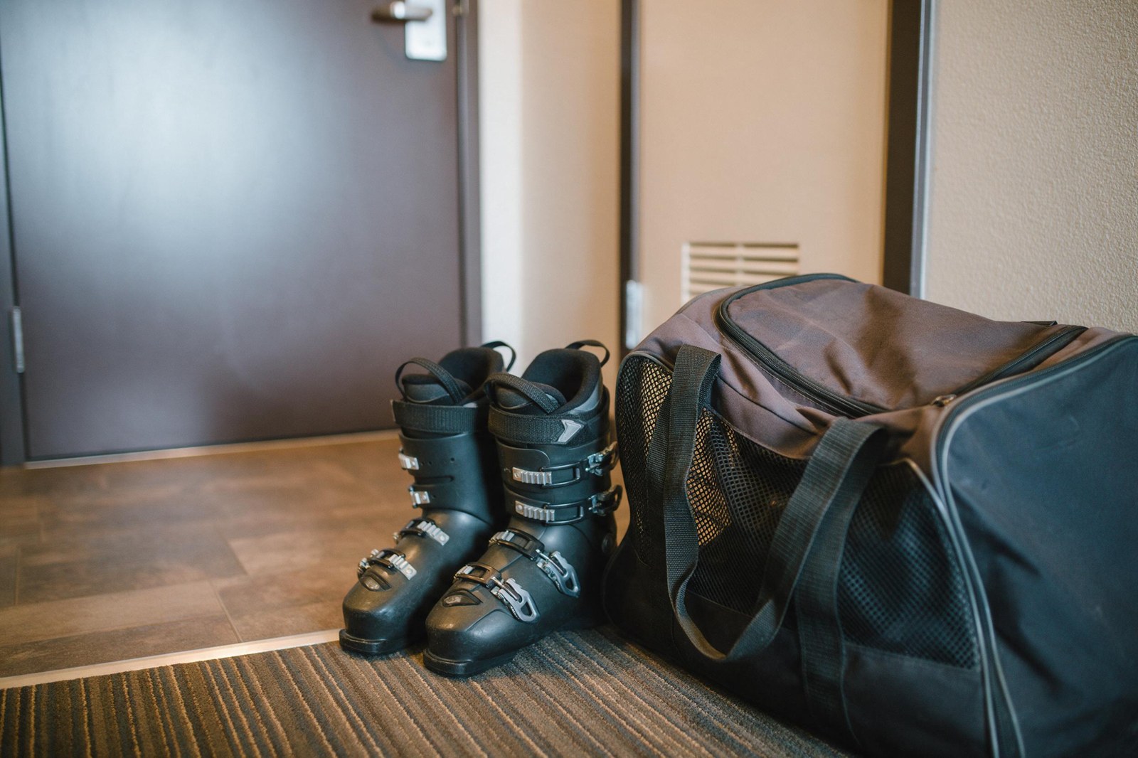 ski boots and vented boot bag by a hotel room door